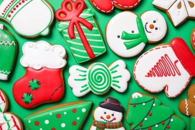 Photo of Tasty homemade Christmas cookies on green background, flat lay