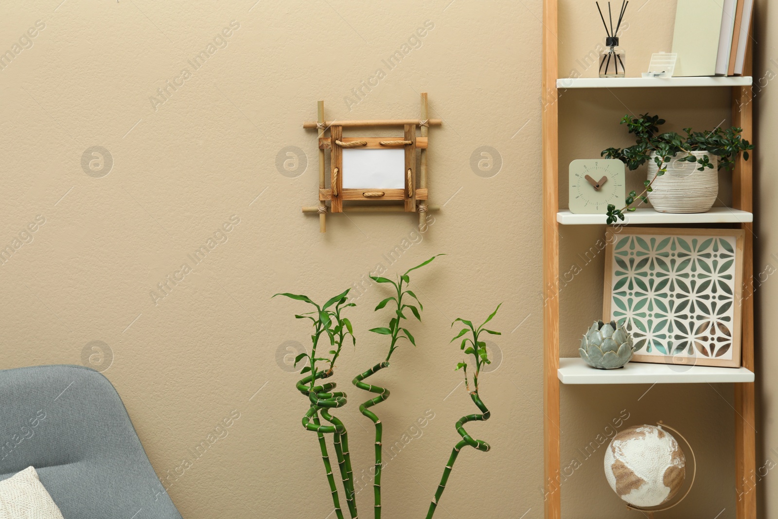 Photo of Stylish room interior with bamboo frame and shelving unit