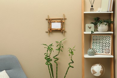 Photo of Stylish room interior with bamboo frame and shelving unit