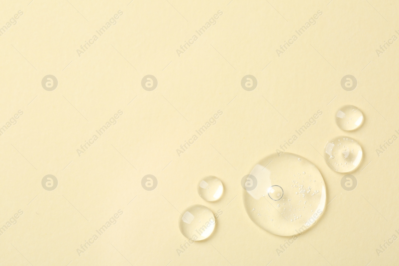 Photo of Samples of cosmetic serum on beige background, flat lay. Space for text