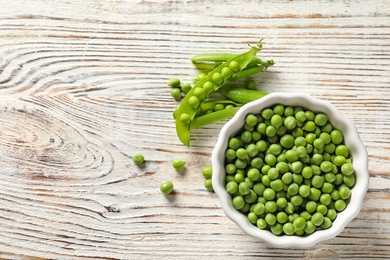 Photo of Flat lay composition with green peas on wooden background