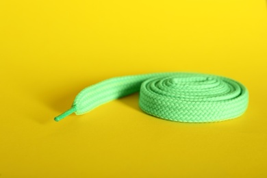 Photo of Rolled mint shoe lace on yellow background