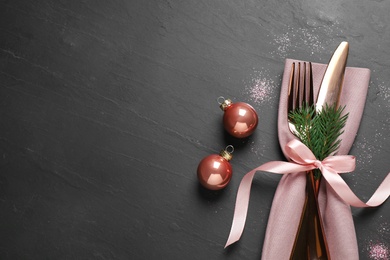 Photo of Cutlery set on black table, top view with space for text. Christmas celebration