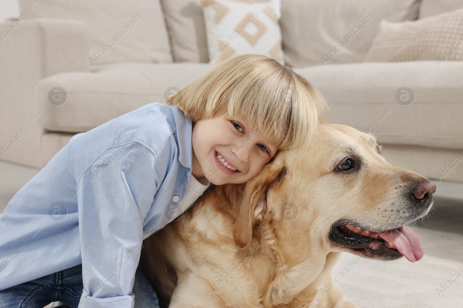 Photo of Cute little child with Golden Retriever at home. Adorable pet