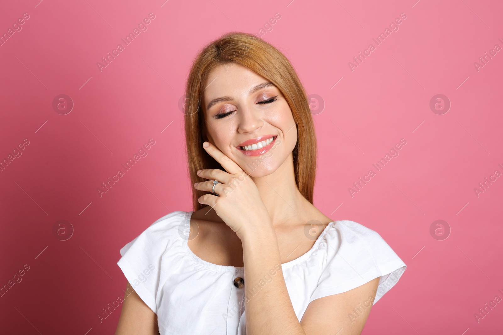 Photo of Happy woman with engagement ring on pink background
