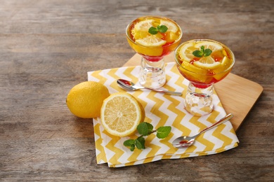 Dessert bowls of lemon jelly served on wooden table. Space for text