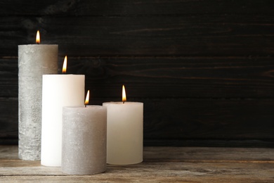 Photo of Alight wax candles on table. Space for text