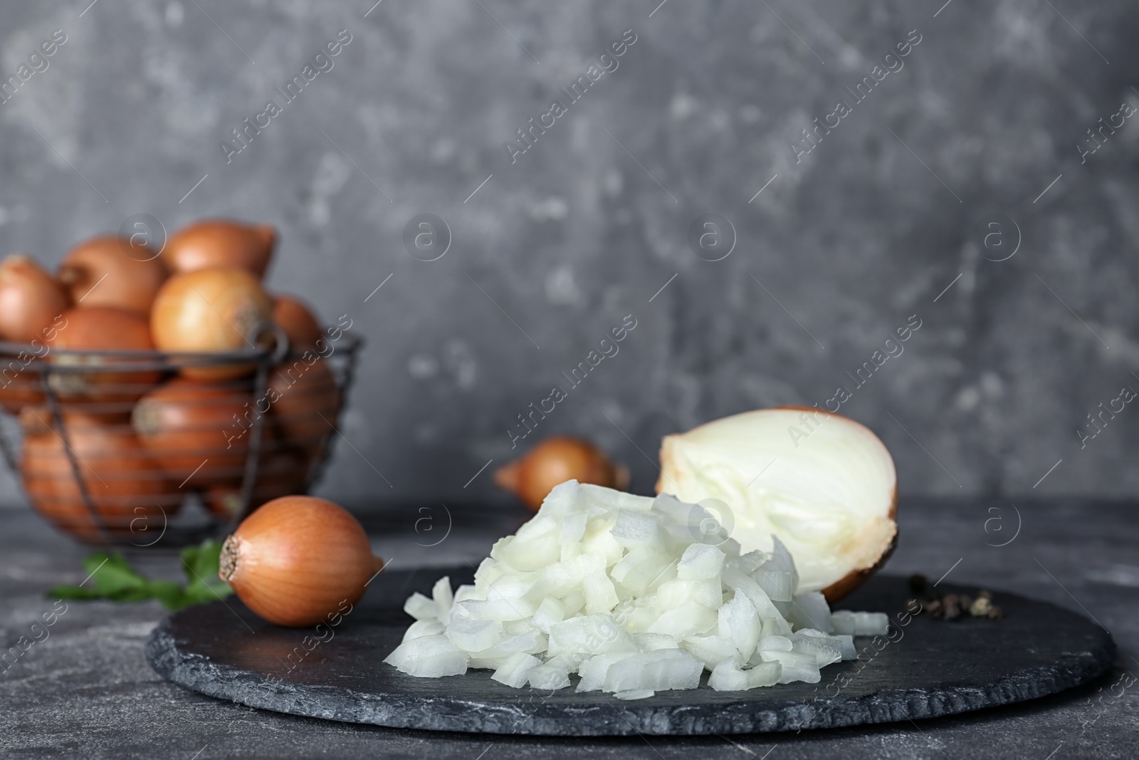 Photo of Slate plate with cut onion on table