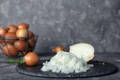 Slate plate with cut onion on table