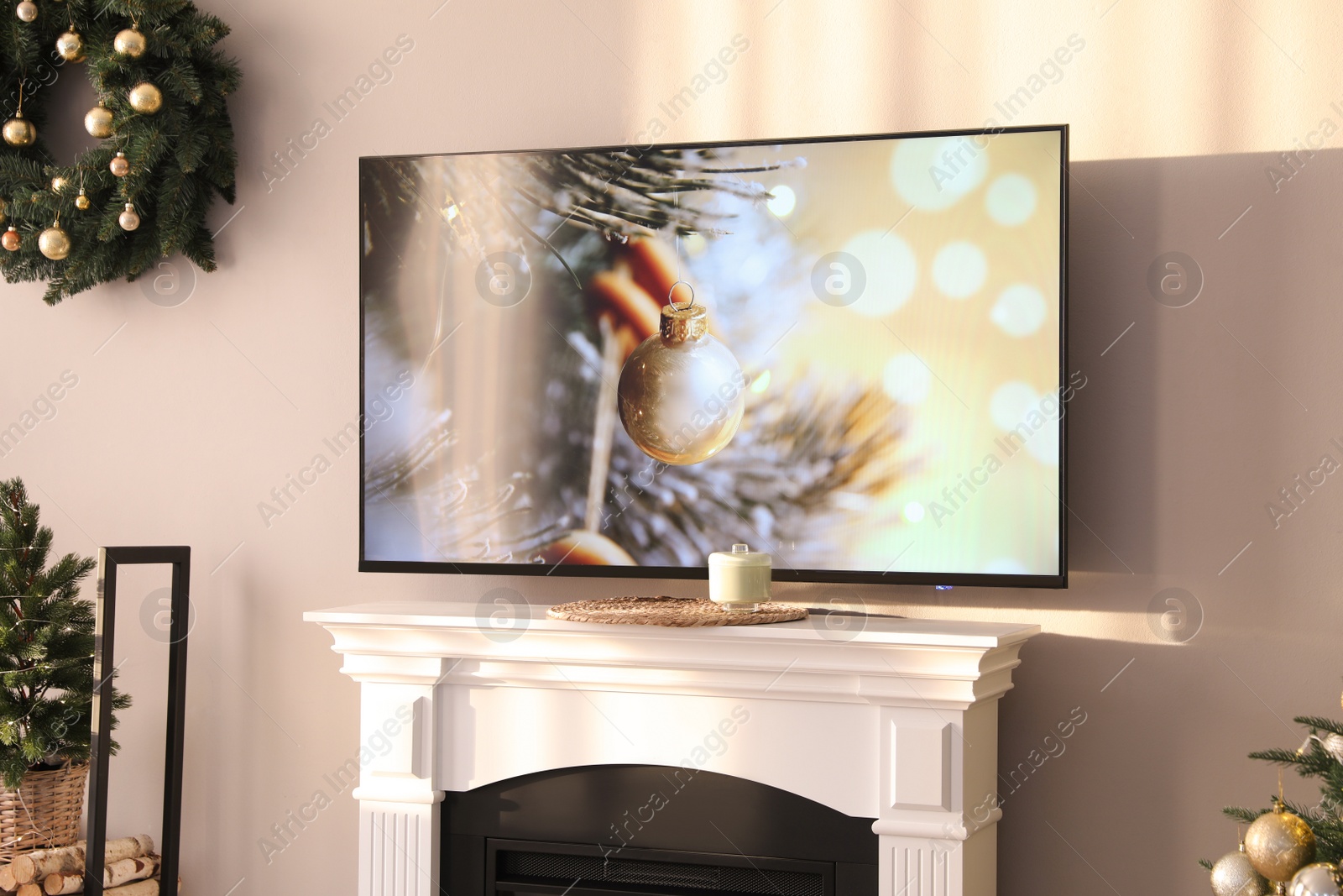 Photo of Modern TV set on light wall in room decorated for Christmas