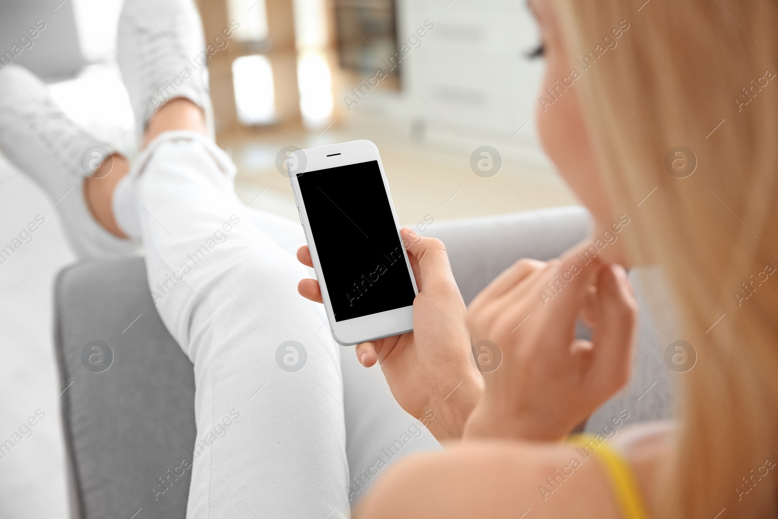 Photo of Young woman using phone indoors