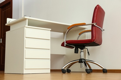 Photo of Stylish workplace interior with modern office chair and desk