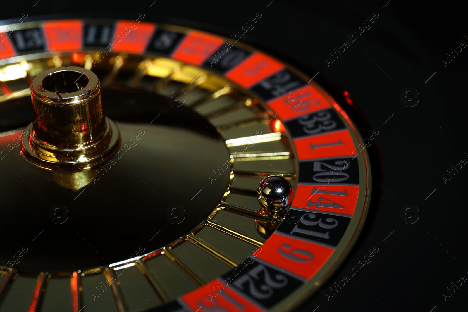 Photo of Roulette wheel with ball, closeup. Casino game