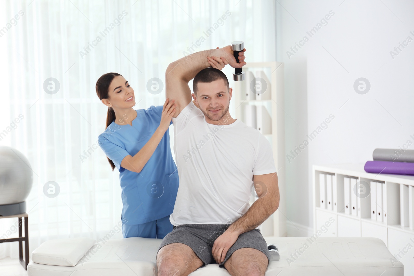 Photo of Doctor working with patient in hospital. Rehabilitation exercises