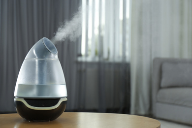 Modern air humidifier on table indoors. Space for text