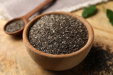Chia seeds in bowl on wooden table, closeup