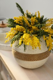 Photo of Beautiful mimosa flowers in vase on wooden table