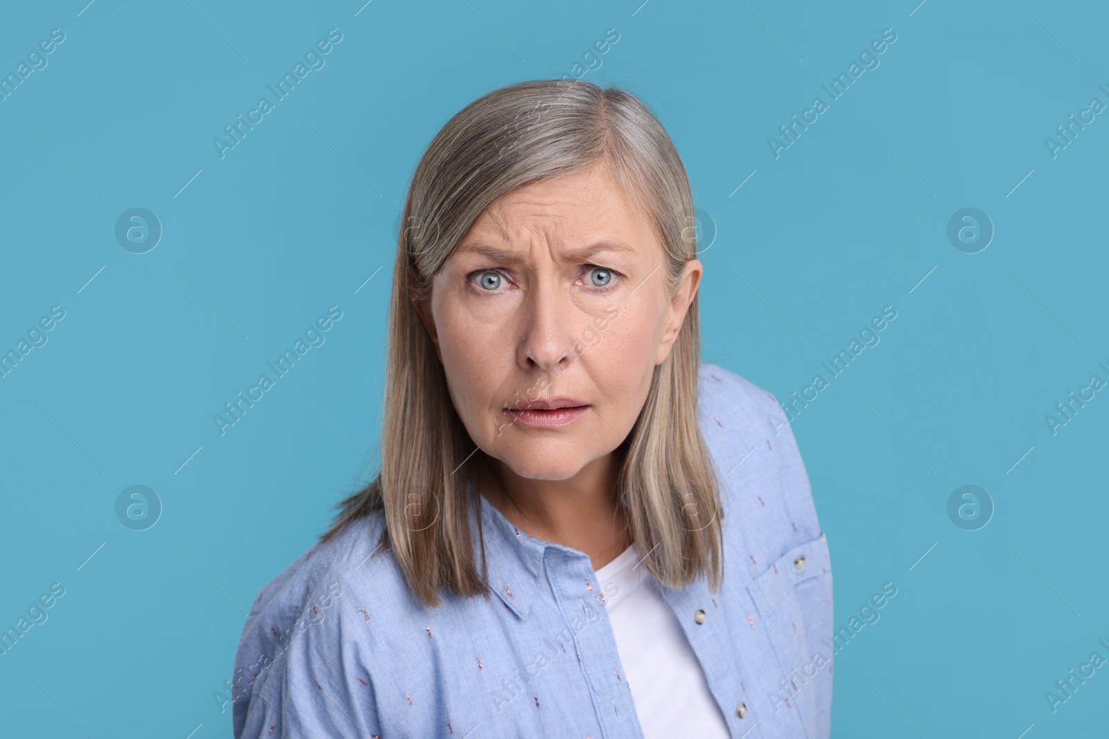 Photo of Portrait of surprised senior woman on light blue background