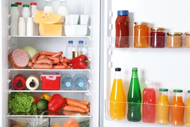 Open refrigerator with many different products, closeup