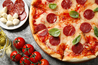 Flat lay composition with hot pepperoni pizza on grey  table