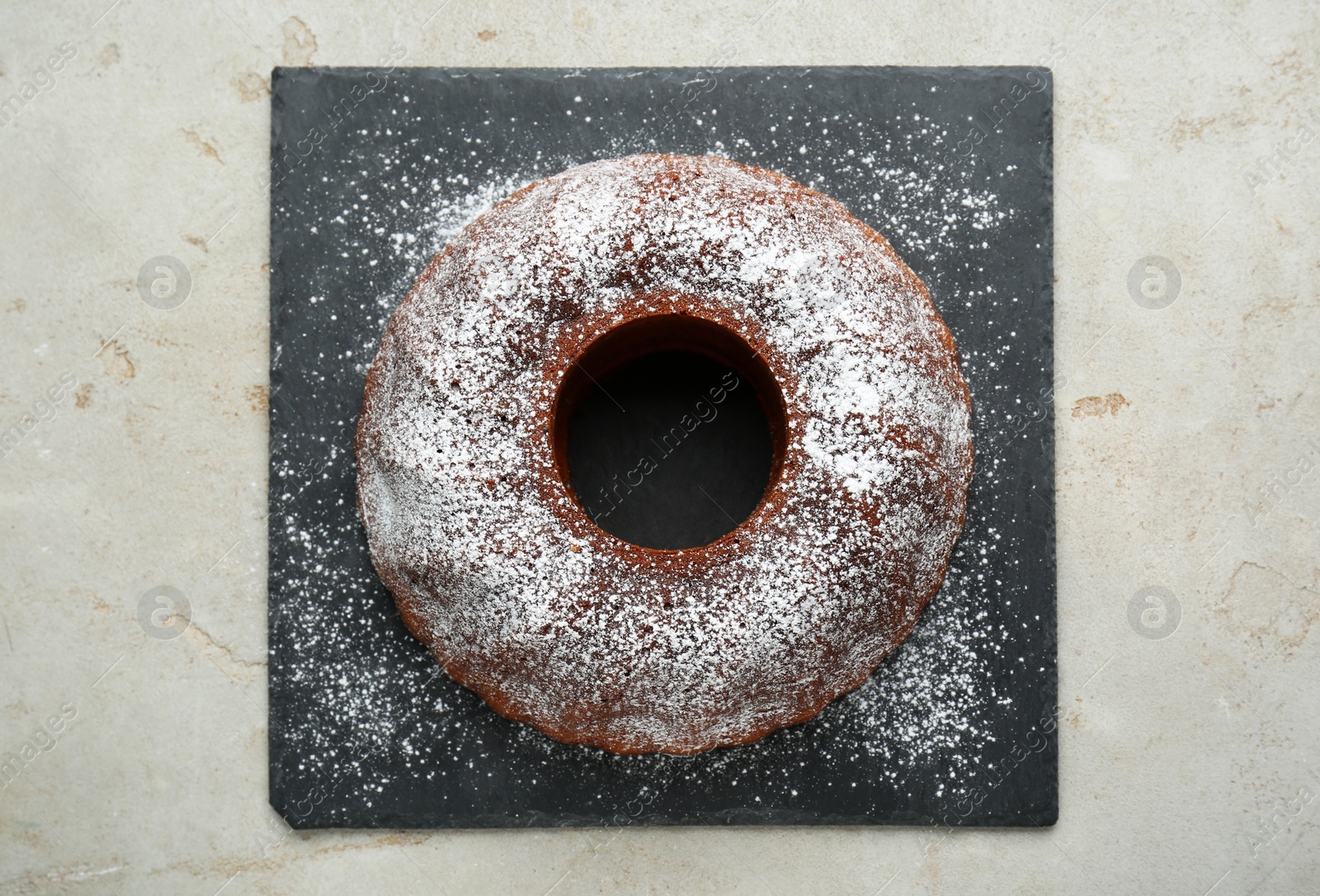 Photo of Delicious homemade yogurt cake with powdered sugar on gray table, top view