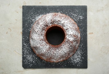 Photo of Delicious homemade yogurt cake with powdered sugar on gray table, top view