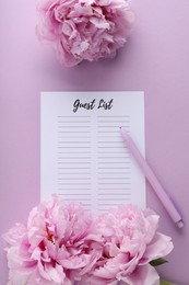 Photo of Guest list, pen and beautiful flowers on violet background, flat lay. Space for text