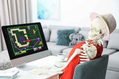 Photo of Human skeleton in red dress playing game at home