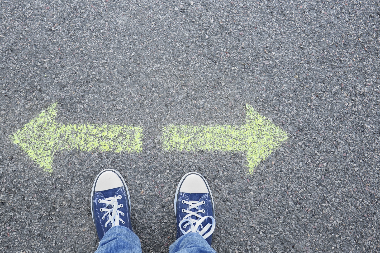 Photo of Man standing on road near arrows marking, closeup