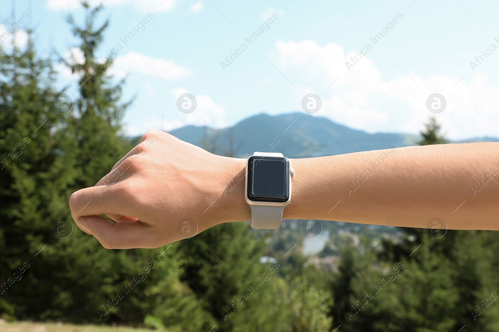 Photo of Woman wearing smart watch with blank screen outdoors, closeup