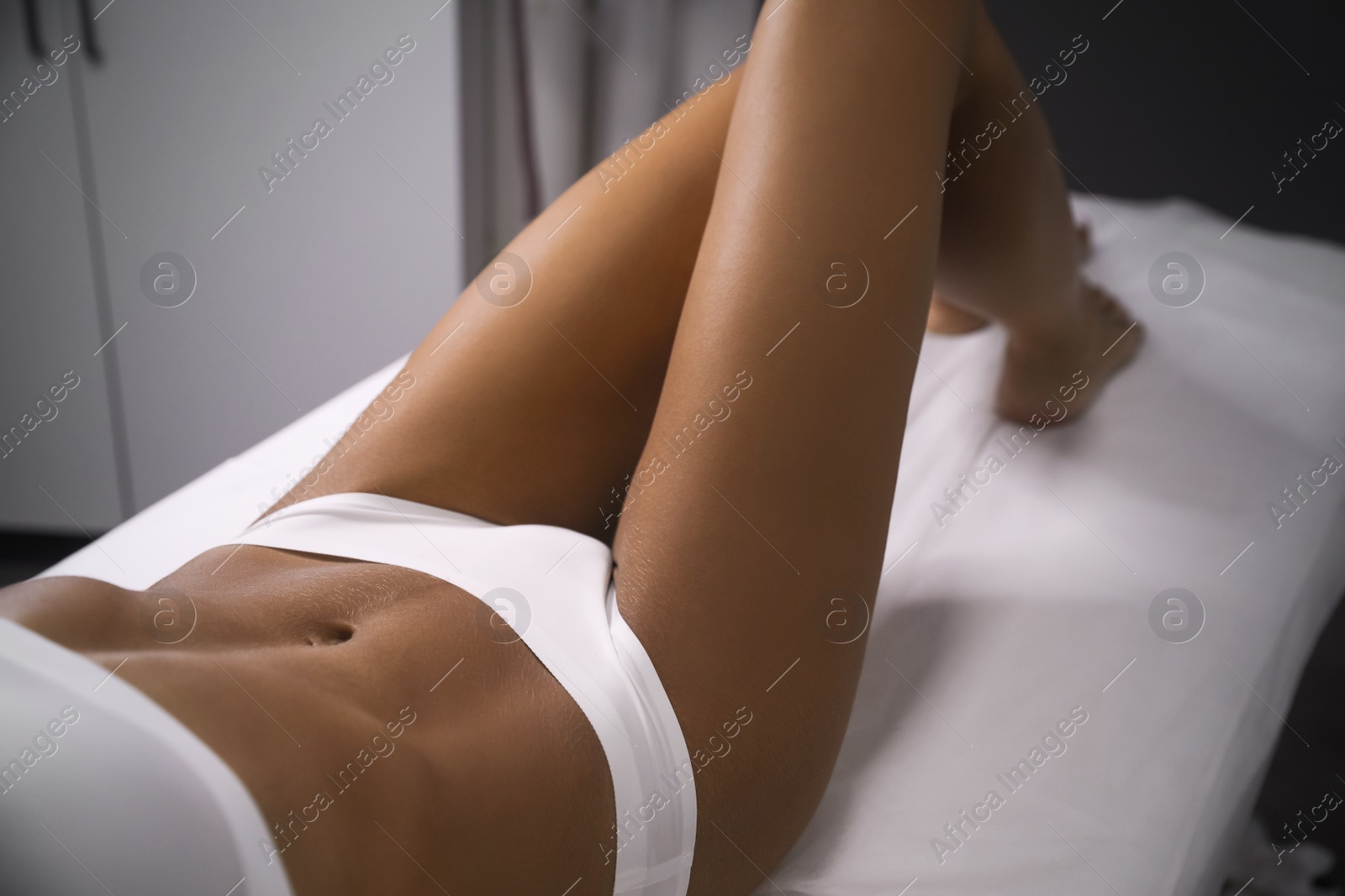 Photo of Young woman showing smooth silky skin after sugaring procedure in salon, closeup