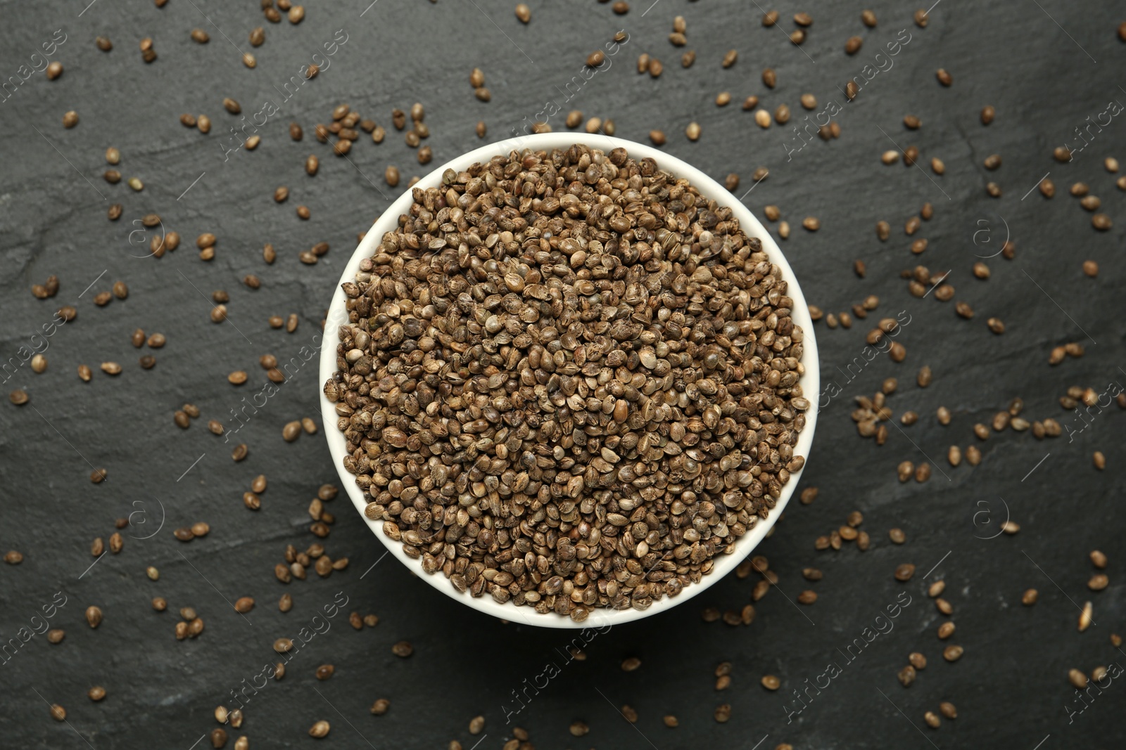 Photo of Ceramic bowl with chia seeds on black table, flat lay. Cooking utensil