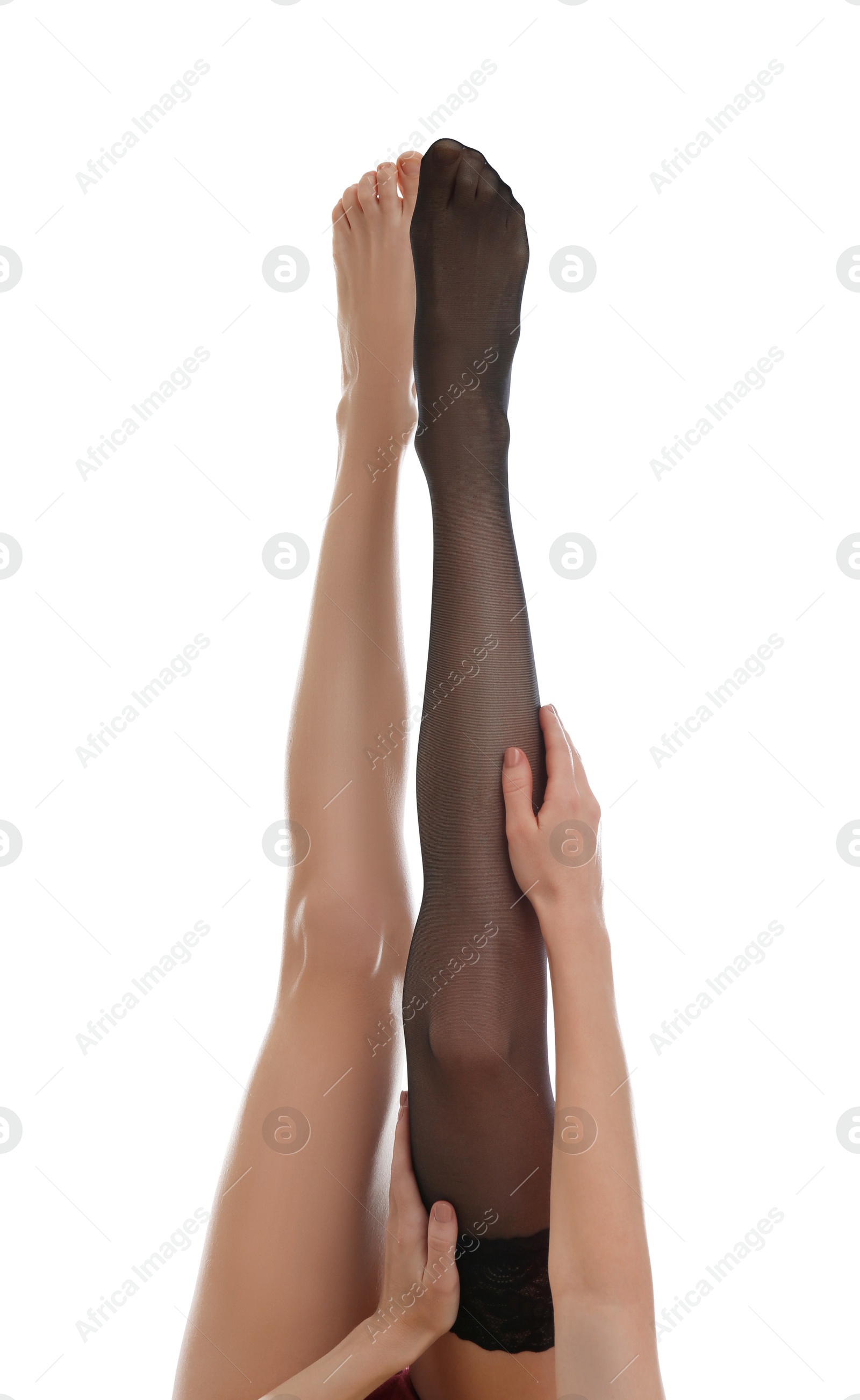 Photo of Young woman putting on stocking against white background, closeup