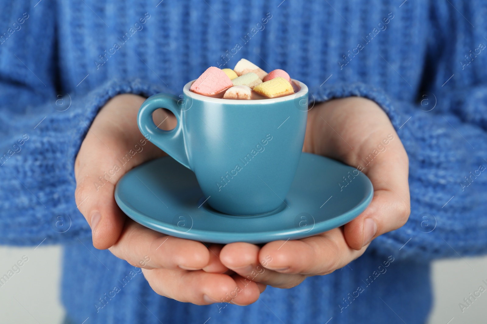 Photo of Woman holding cup of delicious hot chocolate with marshmallows, closeup