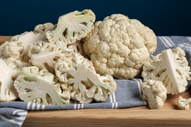 Photo of Cut and whole cauliflower on wooden tray