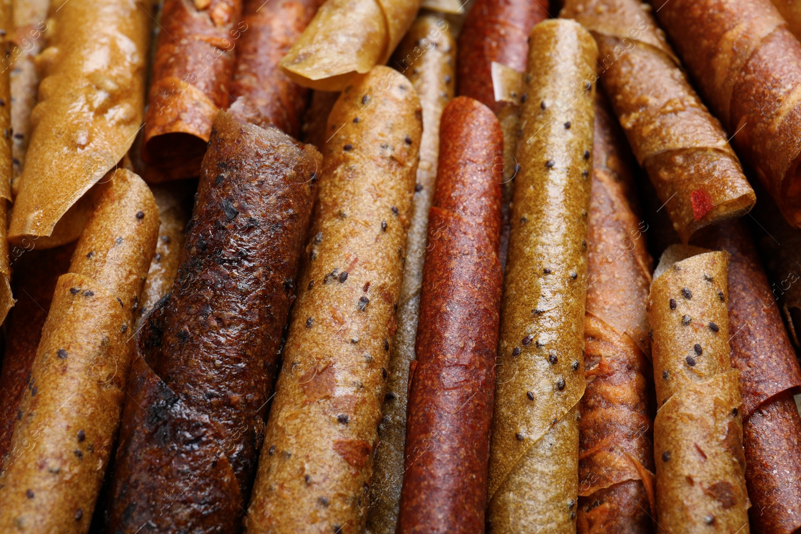 Photo of Delicious fruit leather rolls as background, closeup