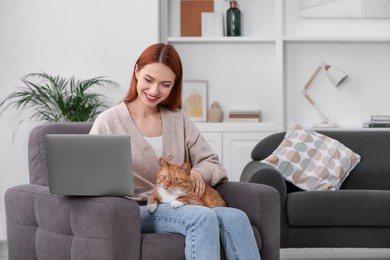 Photo of Happy woman with cat working in armchair at home, space for text