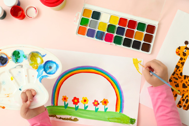 Photo of Cute little child painting at table, top view