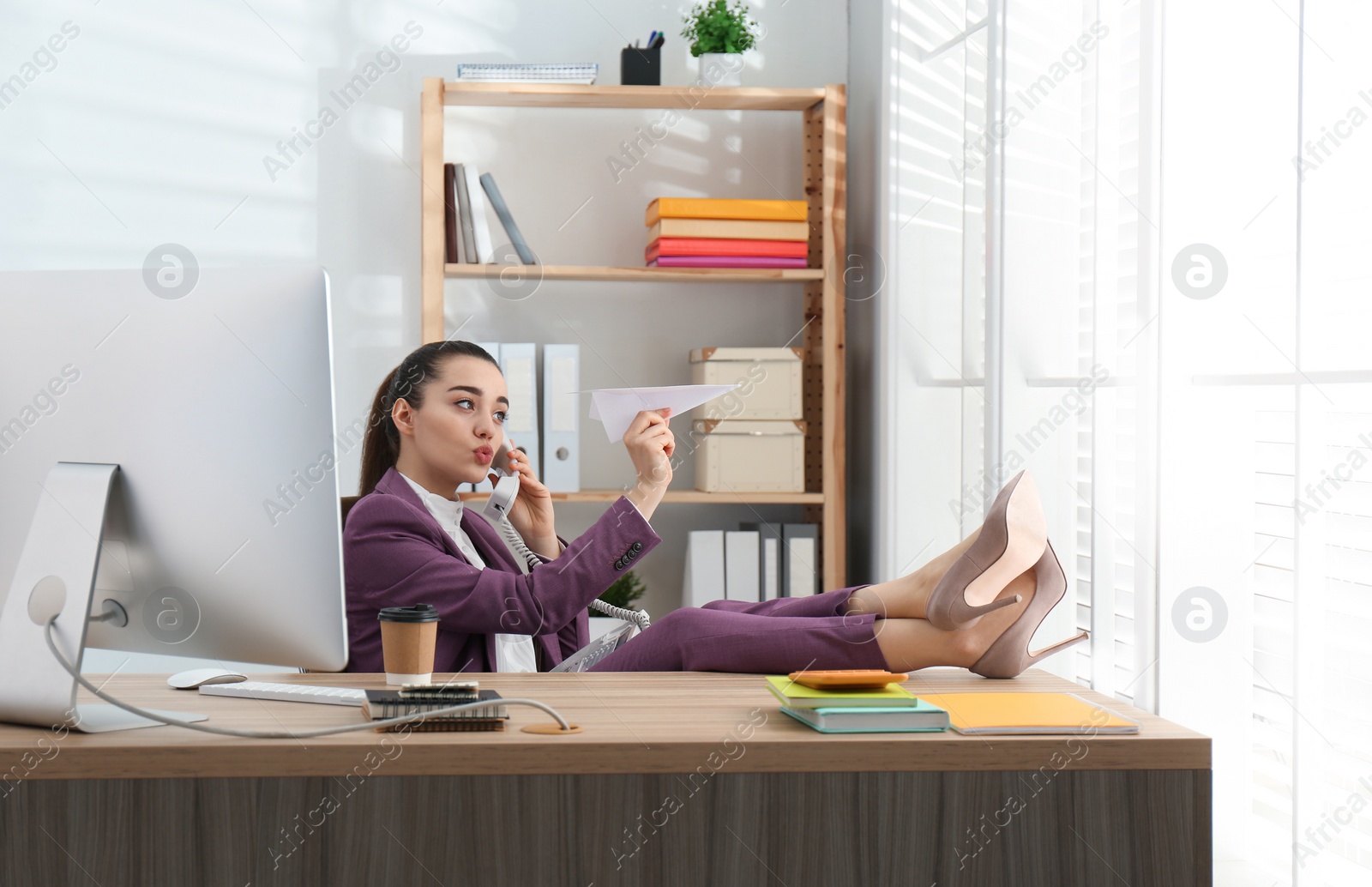 Photo of Lazy employee playing with paper plane in office