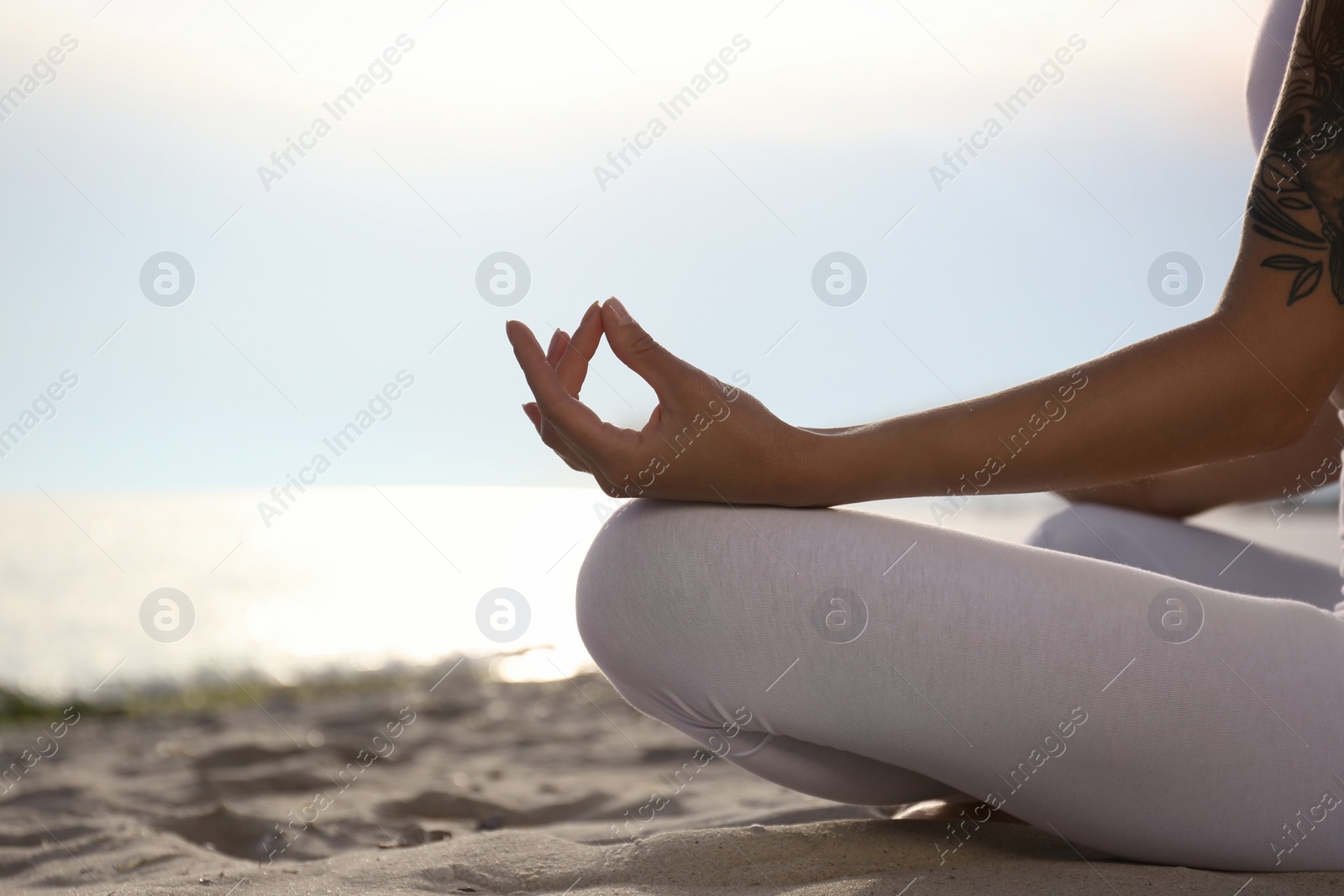 Photo of Young woman practicing zen meditation on beach, closeup. Space for text