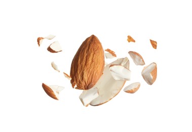 Pieces of tasty almonds falling on white background