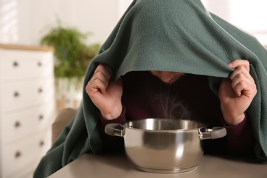 Photo of Man with plaid doing inhalation at table indoors, closeup