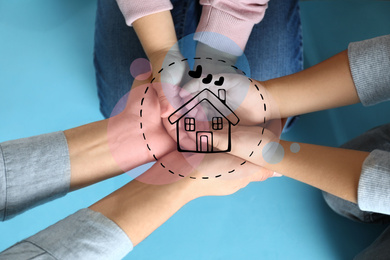 Image of Happy family holding hands and illustration of house on blue background, top view. Adoption concept