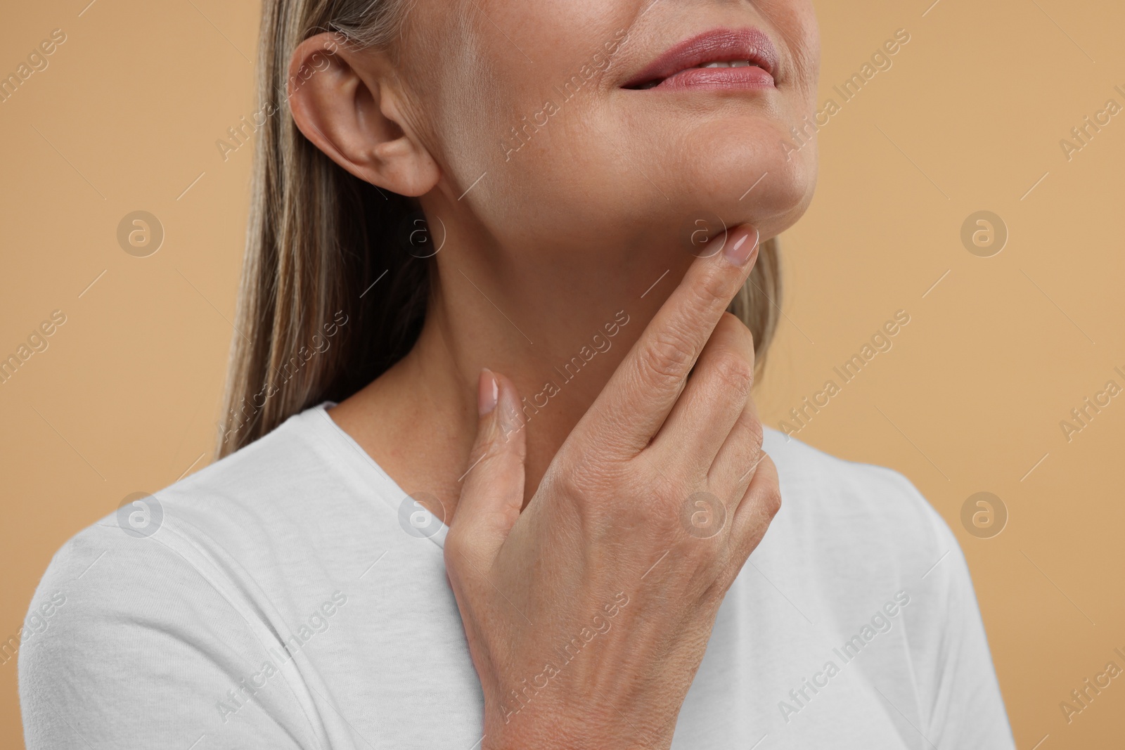 Photo of Mature woman with healthy skin on beige background, closeup