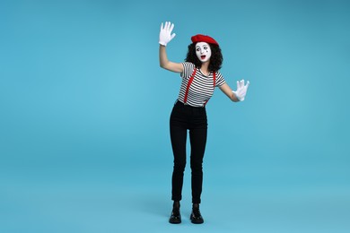 Photo of Funny mime with beret posing on light blue background