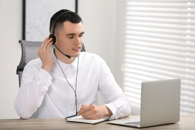 Photo of Hotline operator with headset working in office