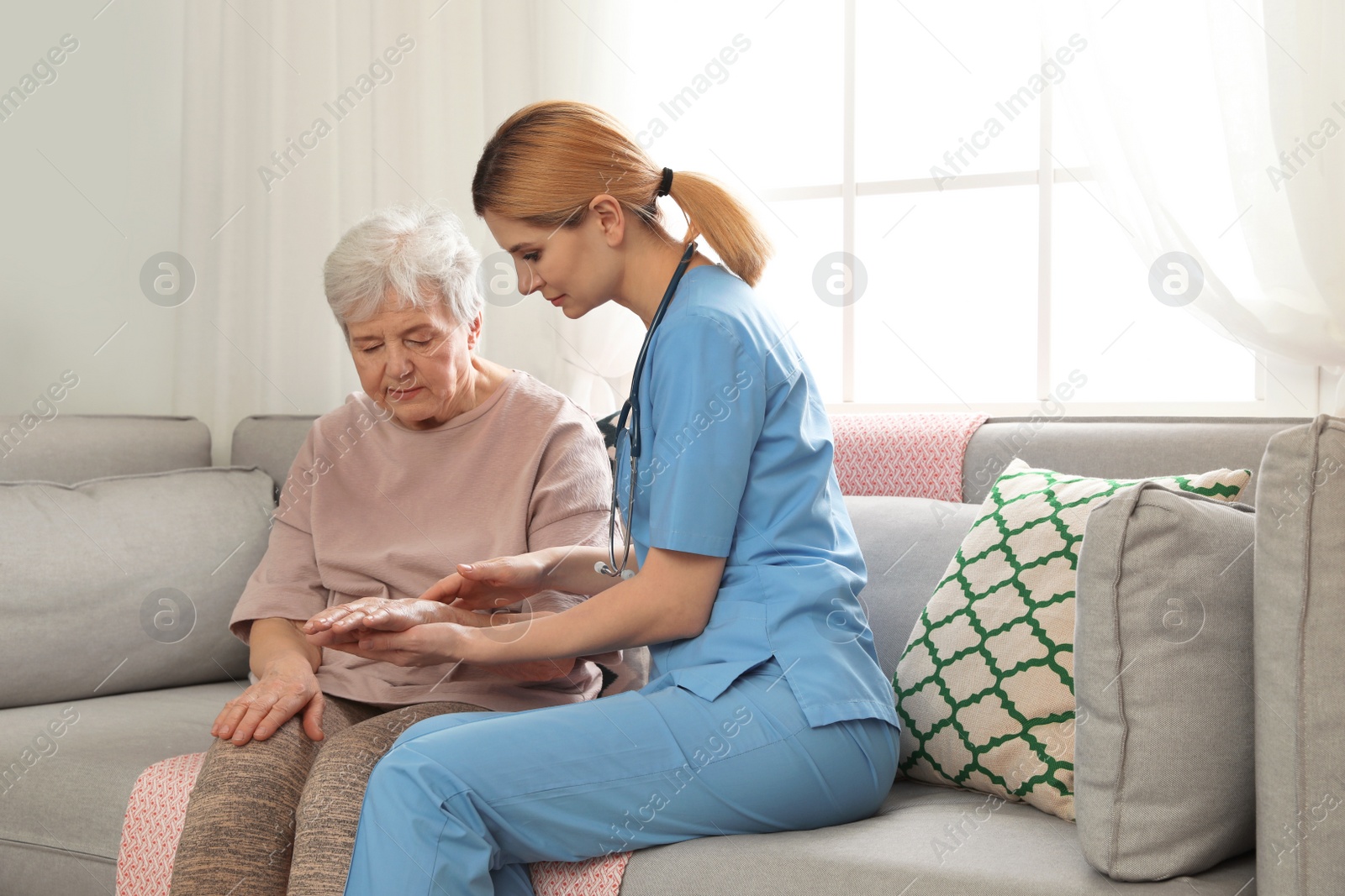 Photo of Nurse with elderly woman indoors. Assisting senior people
