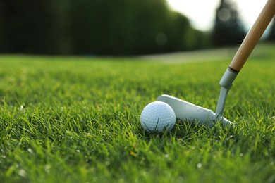 Photo of Hitting golf ball with club on green course, closeup. Space for text