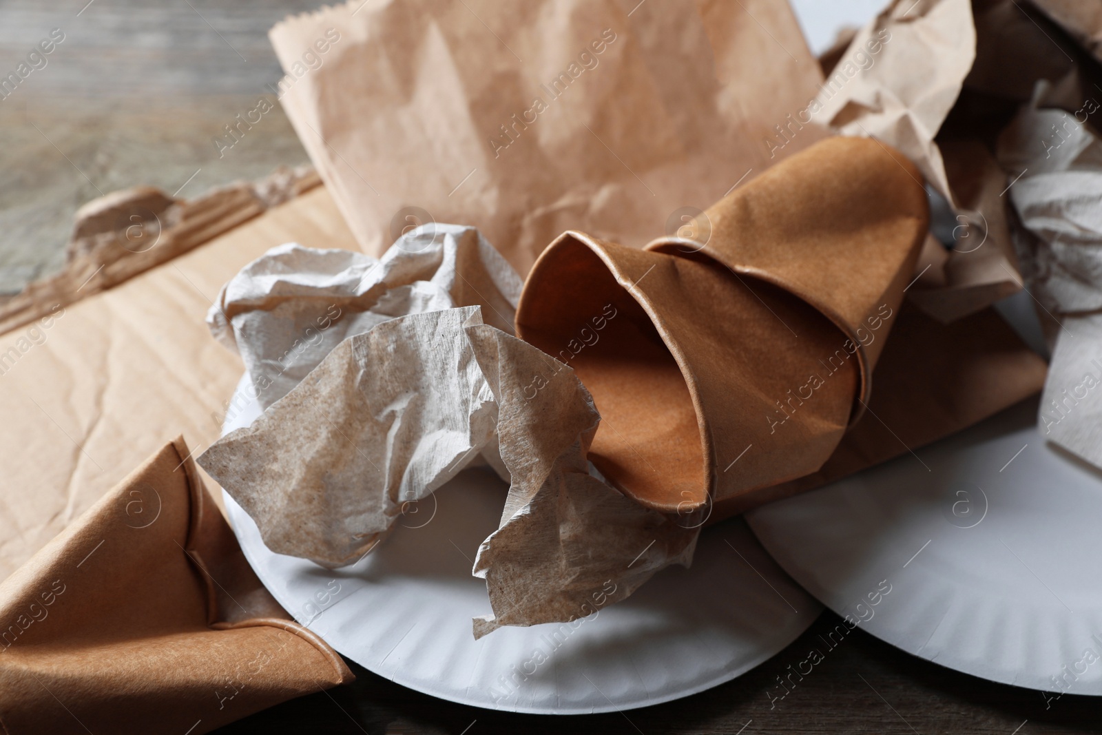 Photo of Different waste paper on wooden table, closeup