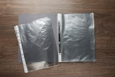 Photo of File folder with punched pockets on wooden table, flat lay